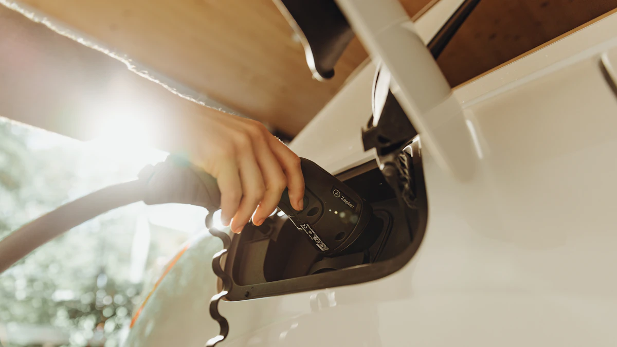 Mano enchufando un cable de carga a un coche eléctrico blanco