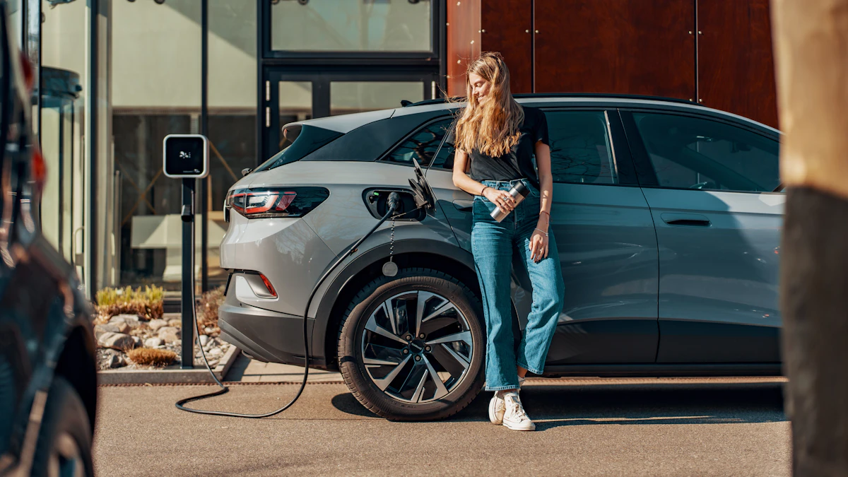 Persona junto a un coche eléctrico azul conectado a un cargador